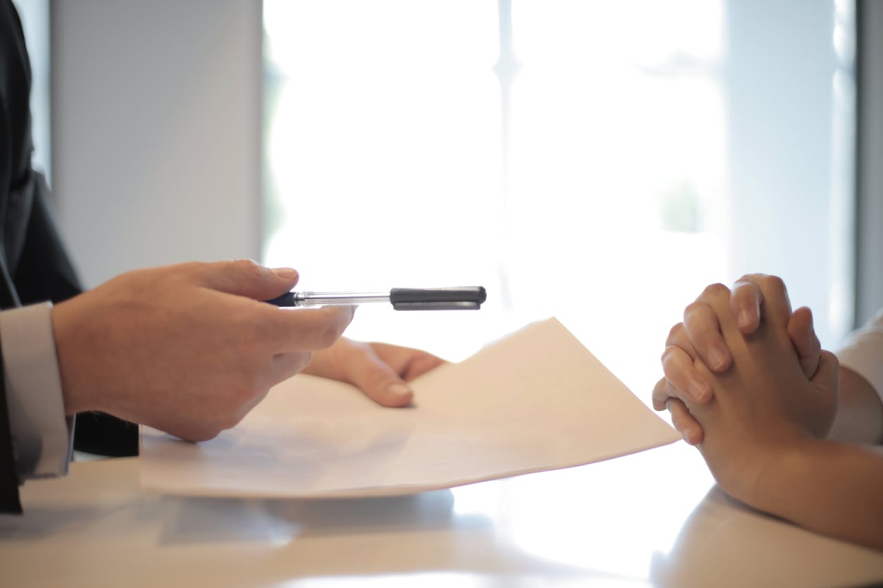 our-story-01 Close-up of a contract signing with hands over documents. Professional business interaction.